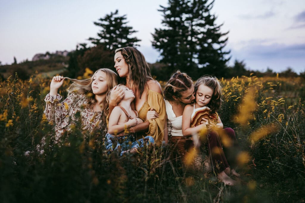 Family Photographer, A mother sits with her four daughters in a field of flowers