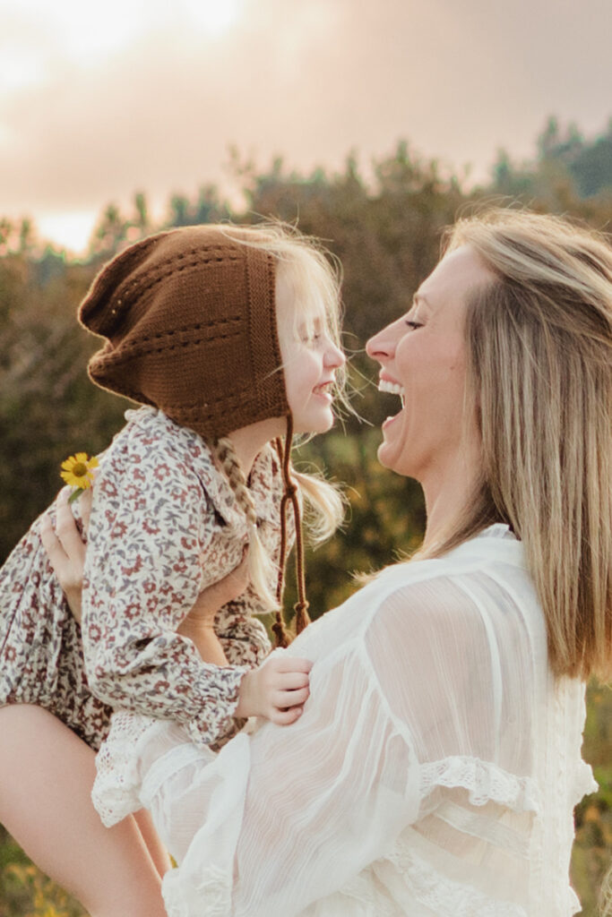 Family Photography, Mother hold up young daughter to her face and laughing together