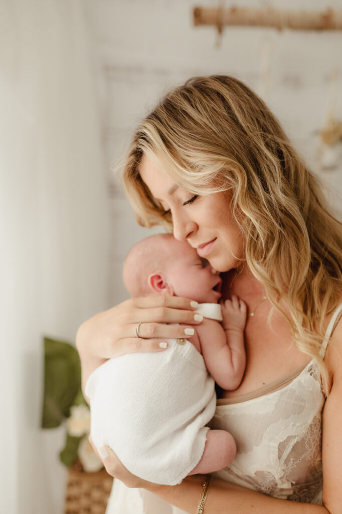 Newborn Photography, mother holding up newborn baby to her chin